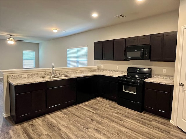 kitchen featuring black appliances, sink, light hardwood / wood-style flooring, a wealth of natural light, and kitchen peninsula