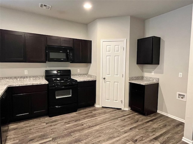 kitchen featuring light stone counters, black appliances, and light wood-type flooring