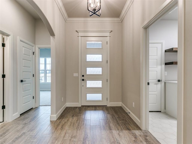 foyer featuring crown molding and a chandelier