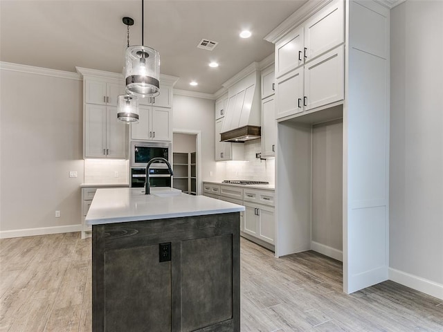 kitchen with stainless steel appliances, white cabinetry, and pendant lighting