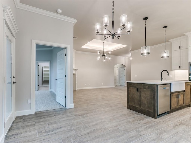 kitchen featuring white cabinetry, sink, a raised ceiling, stainless steel dishwasher, and an island with sink