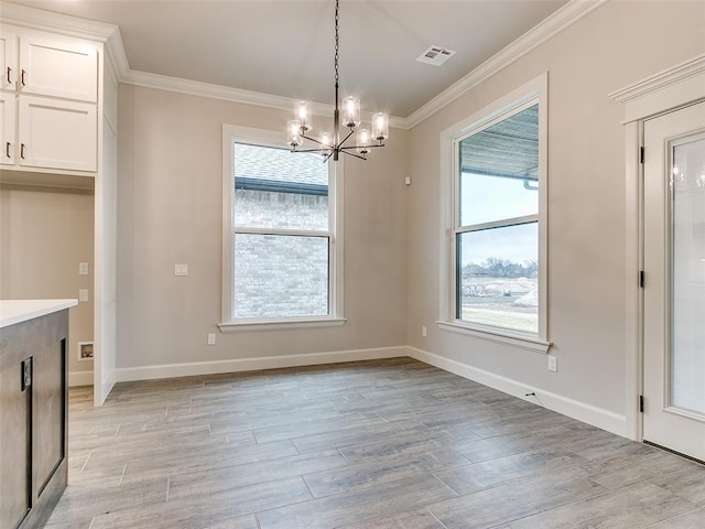 unfurnished dining area featuring ornamental molding, light hardwood / wood-style flooring, and a notable chandelier