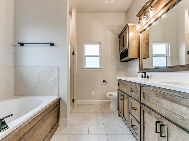 bathroom featuring a bathing tub, tile patterned flooring, vanity, and toilet