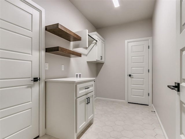 washroom with hookup for a washing machine, light tile patterned flooring, and cabinets