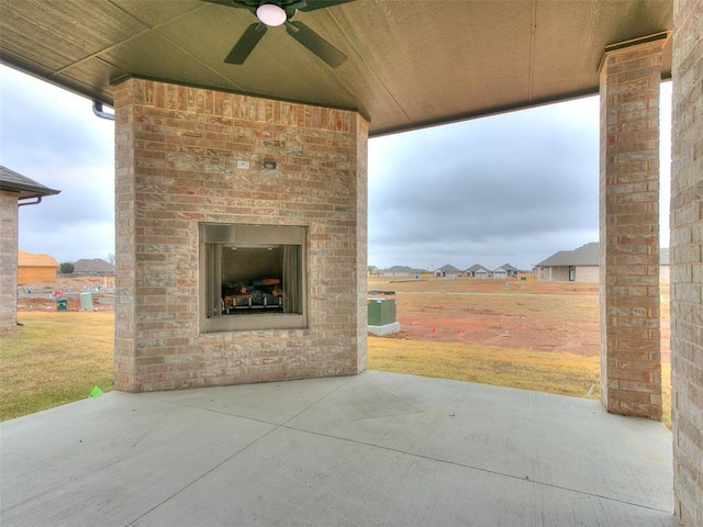 view of patio with an outdoor brick fireplace and ceiling fan