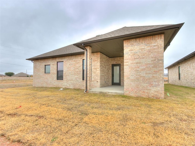 back of house featuring a patio area and a yard