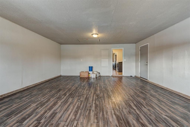 empty room featuring a textured ceiling and dark wood finished floors