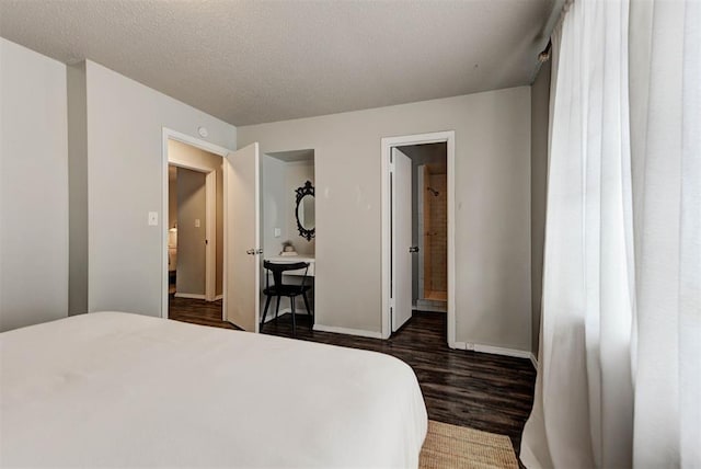 bedroom with connected bathroom, dark wood finished floors, a textured ceiling, and baseboards