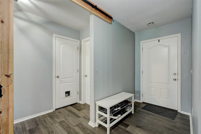 foyer with a barn door and hardwood / wood-style floors