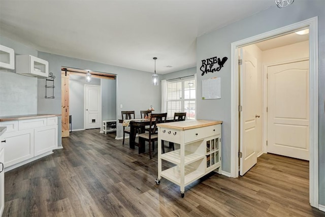 dining space with a barn door and dark hardwood / wood-style floors