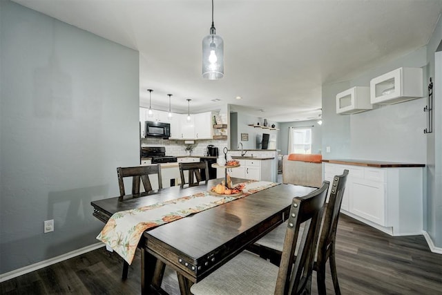 dining area with dark hardwood / wood-style flooring and sink