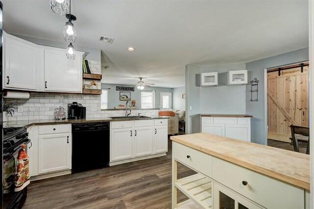 kitchen featuring a barn door, white cabinetry, hanging light fixtures, and black appliances