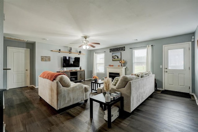 living room featuring ceiling fan and dark hardwood / wood-style floors