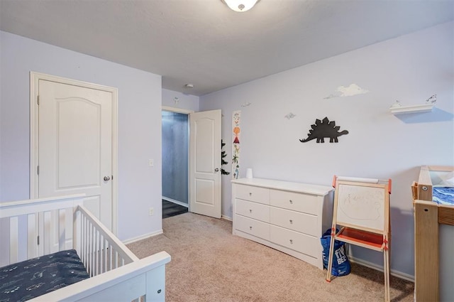 bedroom with a crib and light colored carpet