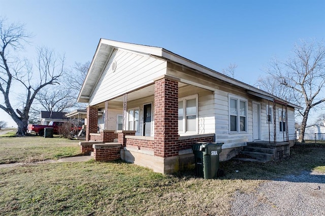 view of property exterior with a yard and a porch