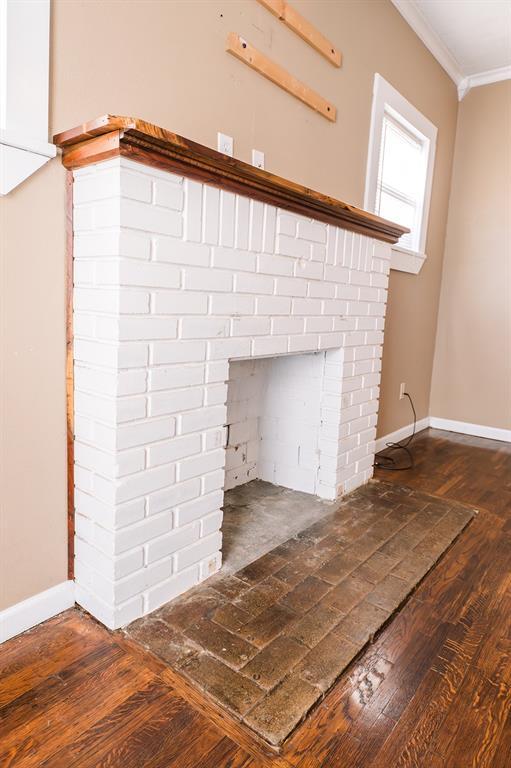 interior details with a fireplace, wood-type flooring, and ornamental molding