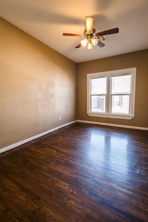 empty room with dark hardwood / wood-style flooring and ceiling fan