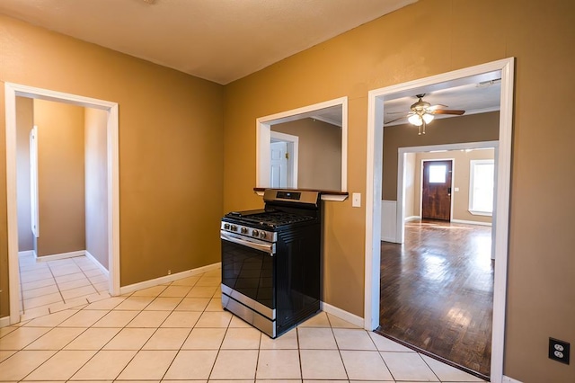 kitchen with stainless steel gas stove, ceiling fan, and light tile patterned floors