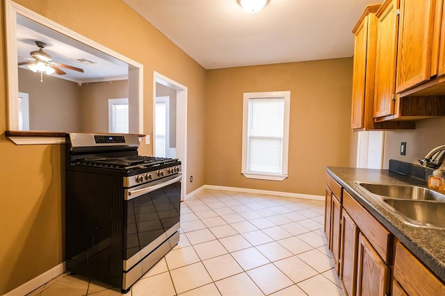 kitchen with ceiling fan, light tile patterned floors, sink, and gas range