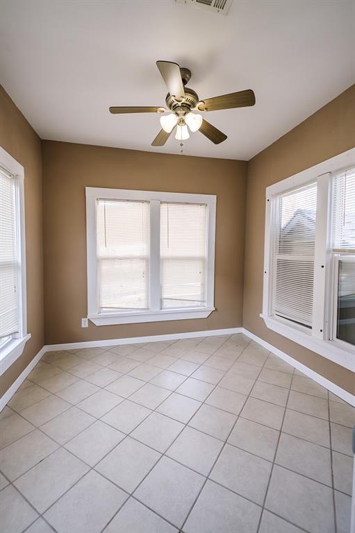 tiled spare room with ceiling fan