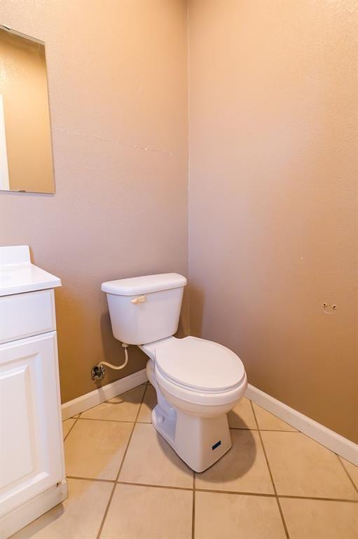 bathroom with tile patterned flooring, vanity, and toilet