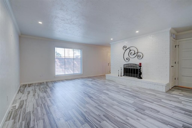 unfurnished living room with a fireplace, light wood-type flooring, and crown molding