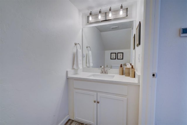 bathroom with vanity and lofted ceiling