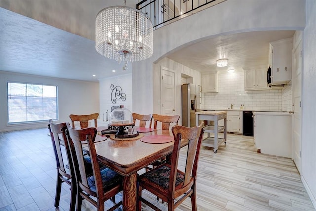 dining room with light wood-type flooring and an inviting chandelier