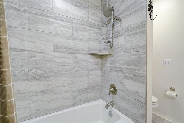 bathroom featuring toilet and tiled shower / bath