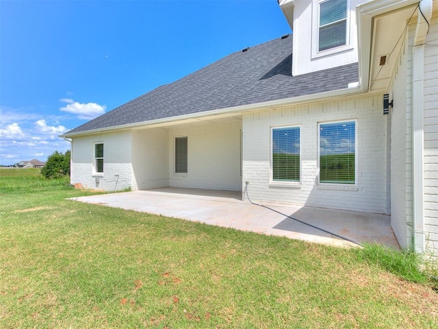 rear view of property with a lawn and a patio