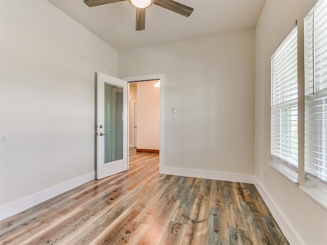 empty room featuring ceiling fan, french doors, and light hardwood / wood-style floors