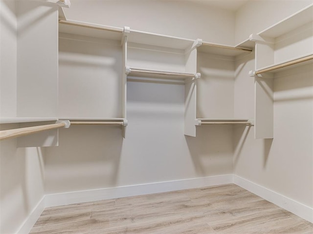 walk in closet with light hardwood / wood-style floors