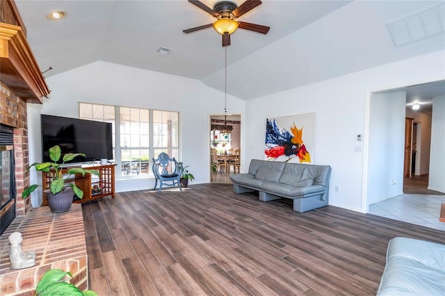 living room featuring ceiling fan, wood-type flooring, a fireplace, and vaulted ceiling