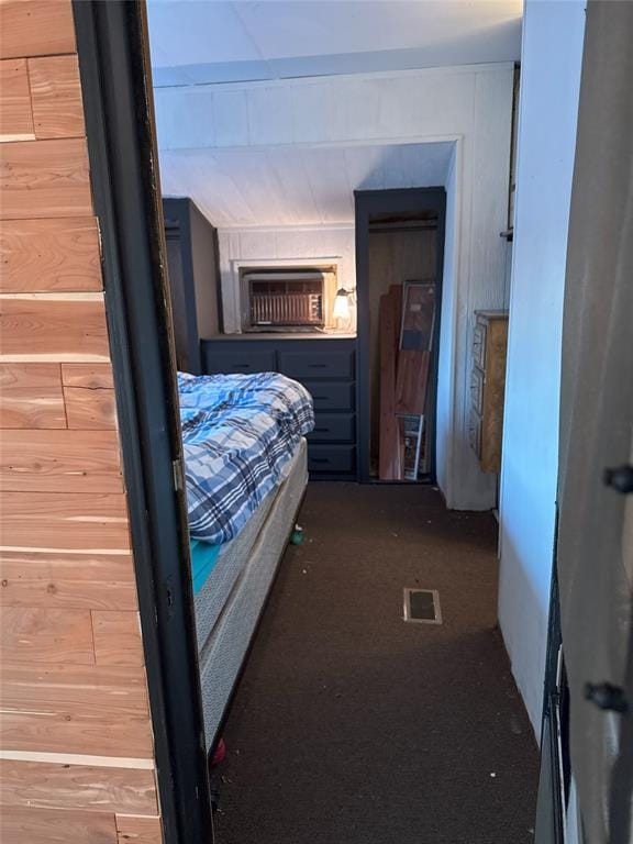 bedroom featuring a wall mounted air conditioner and wood walls