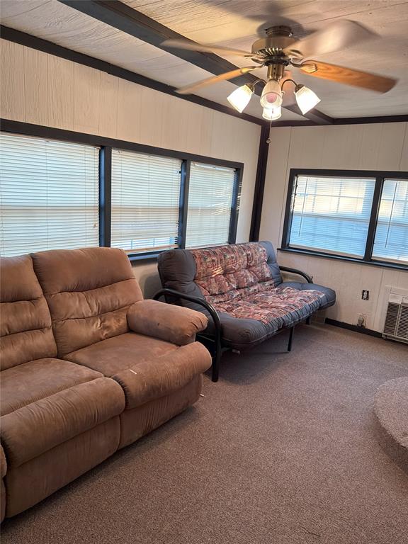 carpeted living room with beamed ceiling and ceiling fan