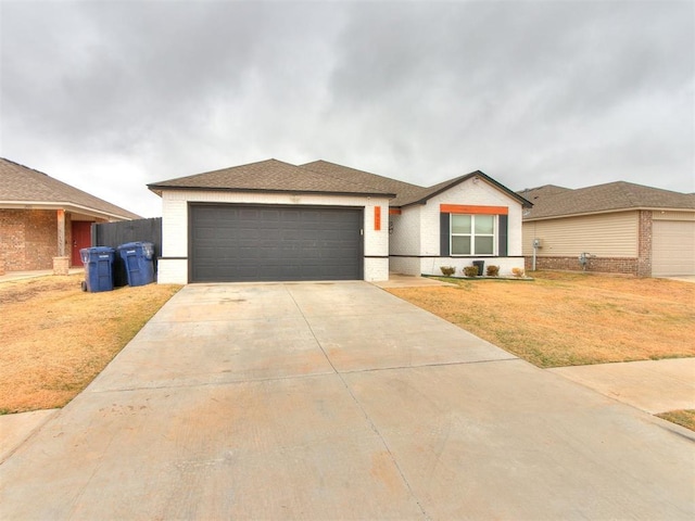 ranch-style house featuring a garage and a front lawn