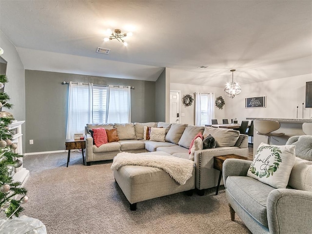 living room featuring carpet, lofted ceiling, and an inviting chandelier