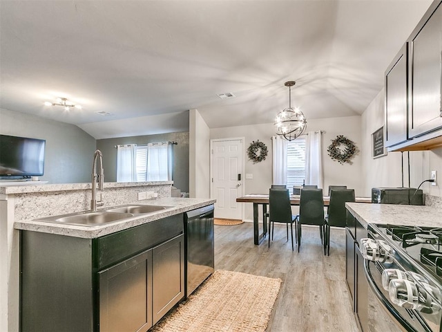 kitchen with lofted ceiling, sink, hanging light fixtures, an island with sink, and stainless steel appliances