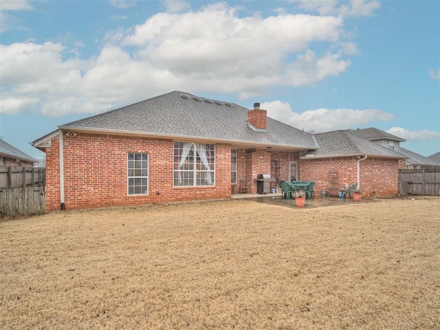 back of property with a lawn and a patio area