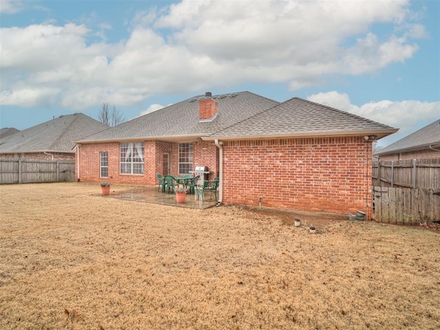 back of property with a yard and a patio area