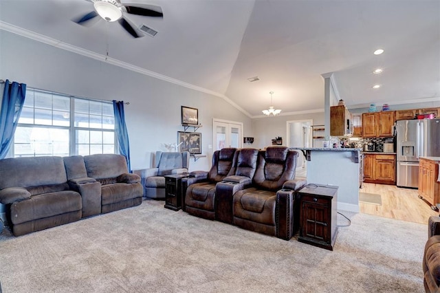 living room with crown molding, ceiling fan with notable chandelier, light colored carpet, and vaulted ceiling