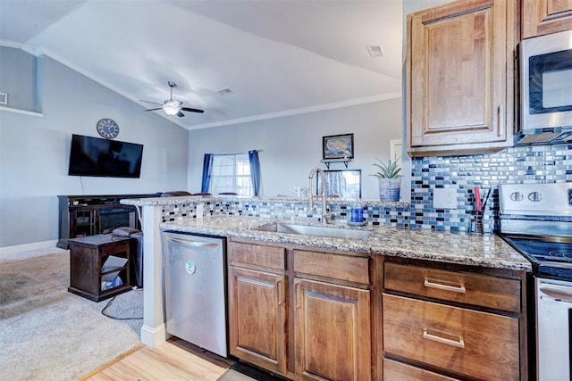 kitchen with decorative backsplash, sink, stainless steel appliances, and vaulted ceiling