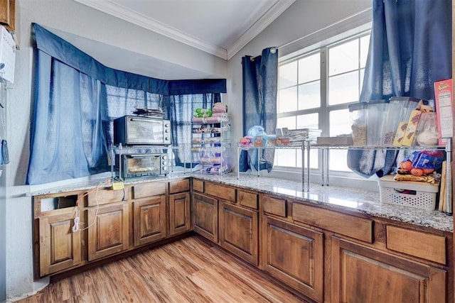 bar featuring light stone countertops, ornamental molding, light wood-type flooring, and lofted ceiling