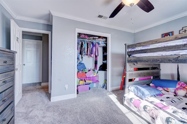 carpeted bedroom featuring ceiling fan, crown molding, and a closet