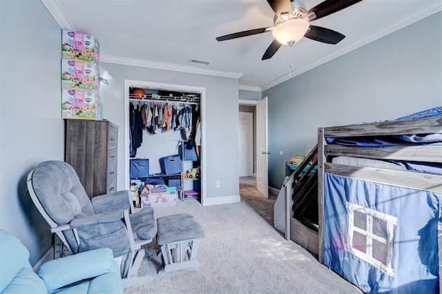 bedroom featuring carpet flooring, ceiling fan, ornamental molding, and a closet