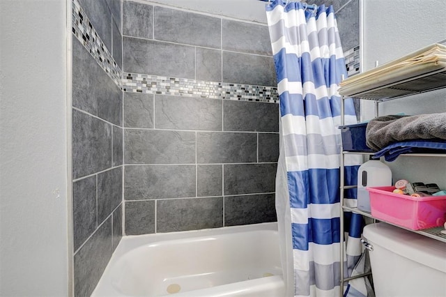 bathroom with toilet and shower / bath combo with shower curtain