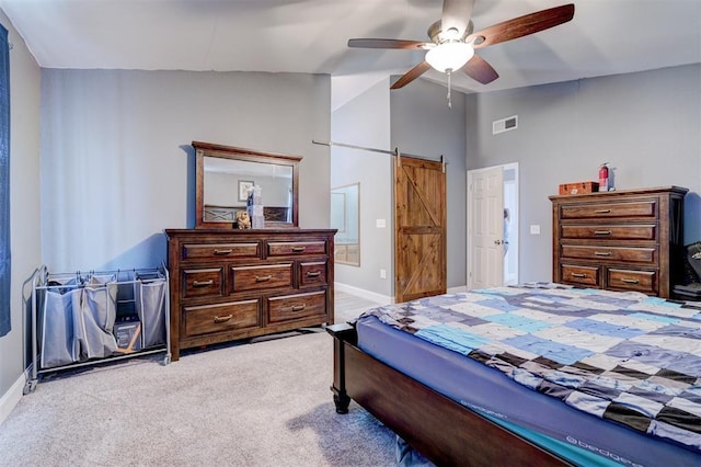 carpeted bedroom featuring a barn door, ceiling fan, and vaulted ceiling