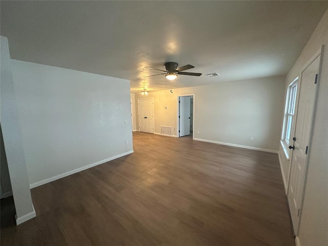 spare room featuring ceiling fan and dark wood-type flooring