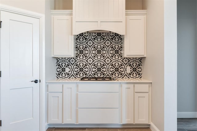 kitchen with white cabinetry, stainless steel gas cooktop, and custom exhaust hood