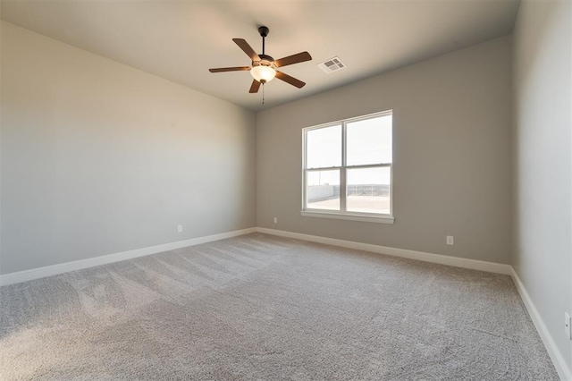 empty room featuring ceiling fan and carpet